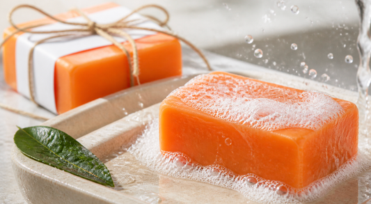 Savon orange au gingembre et curcuma avec mousse sur un porte-savon